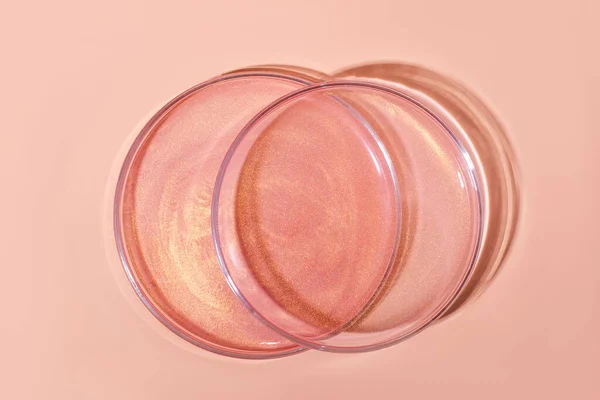 Liquid rose gold. Or a pink liquid with glitter. In Petri dishes. Laboratory research of cosmetics, gel, medicine. Chemistry