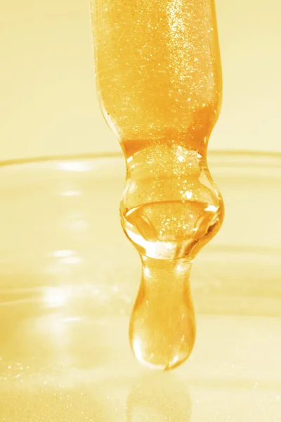 Труба Капающей Желтой Жидкостью Жидкое Золото Крупный План Золотом Фоне — стоковое фото