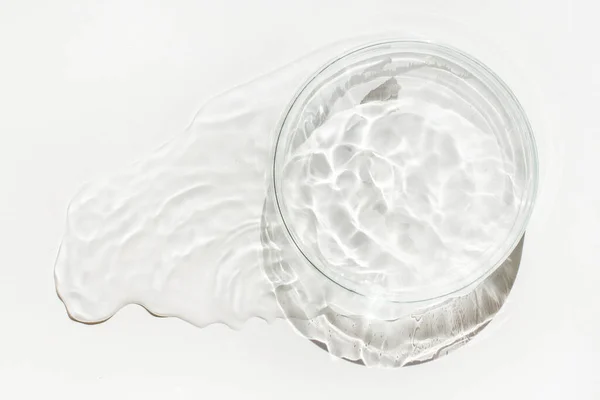 stock image An empty Petri dish is poured out with spilled water or liquid. Waves, lab, reaction.