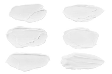 Bir dizi farklı krema darbeleri. Gölgesiz kozmetik krem vuruşları. Beyaz bir arkaplanda izole edilmiş.