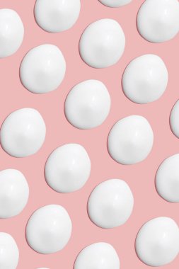 Bir sürü kozmetik kremi. Hafif, pürüzsüz yüzey. Yayılabilir krem dokusu. Sıvı kremsi felçler. Pembe arka planda. Kozmetik arkaplan, afiş.