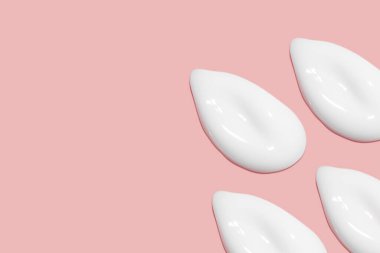 Bir sürü kozmetik kremi. Hafif, pürüzsüz yüzey. Yayılabilir krem dokusu. Sıvı kremsi felçler. Pembe arka planda. Kozmetik arkaplan, afiş.