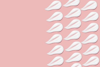 Bir sürü kozmetik kremi. Hafif, pürüzsüz yüzey. Yayılabilir krem dokusu. Sıvı kremsi felçler. Pembe arka planda. Kozmetik arkaplan, afiş.