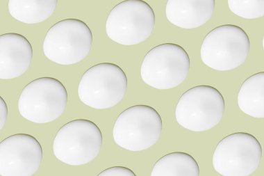 Bir sürü kozmetik kremi. Hafif, pürüzsüz yüzey. Arka arkaya. Bir açıdan. Üst Manzara. Akan krema dokusu. Sıvı kremsi felçler. Yeşil arka planda. Kozmetik arkaplan, afiş.