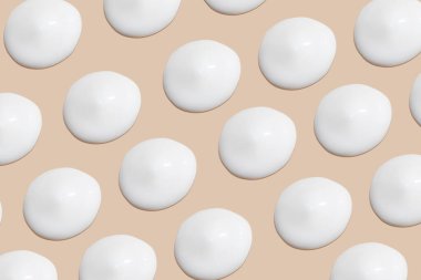 Bej bir arka planda beyaz krema darbeleri.. 