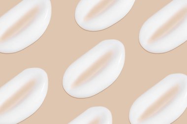 Bej bir arka planda beyaz krema darbeleri.. 