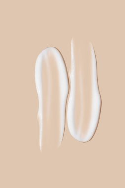 Bej bir arka planda beyaz krema darbeleri.. 