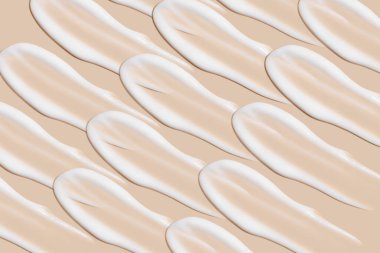 Bej bir arka planda beyaz krema darbeleri.. 