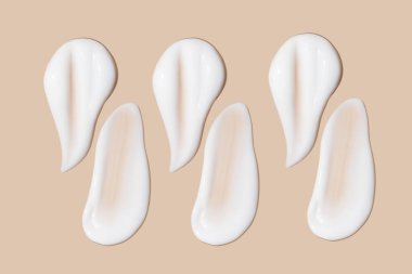 Bej bir arka planda beyaz krema darbeleri.. 