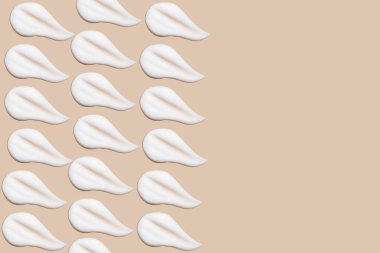 Bej bir arka planda beyaz krema darbeleri.. 