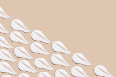 Bej bir arka planda beyaz krema darbeleri.. 