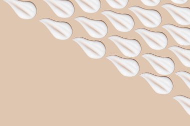 Bej bir arka planda beyaz krema darbeleri.. 