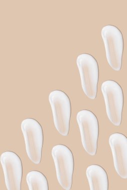 Bej bir arka planda beyaz krema darbeleri.. 