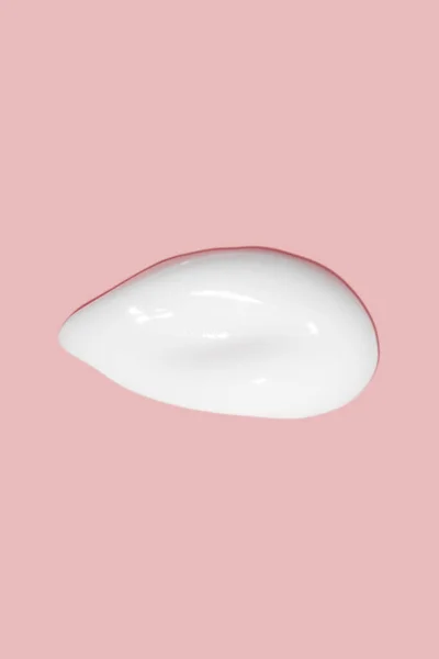 一抹化妆品霜 轻盈光滑的表面可扩展奶油的纹理 液体奶油涂片 粉红的背景 — 图库照片