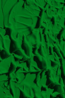 Yeşil boyanın sızdıran dokusu. Lekeli boya sıvı yeşil renktir. Arkaplan yeşili hareket ediyor, ışığa doğru yayılıyor. Yüzeye uygulanır. Çimenli, doğal