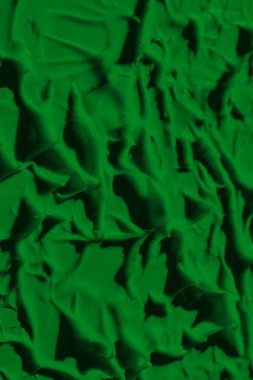 Yeşil boyanın sızdıran dokusu. Lekeli boya sıvı yeşil renktir. Arkaplan yeşili hareket ediyor, ışığa doğru yayılıyor. Yüzeye uygulanır. Çimenli, doğal