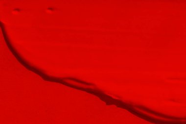 Parlak kırmızı rengin güzel dokusu. Kırmızı renk. Ruj dokusu, göz farı, boya, sıvı kırmızı. leke, leke, leke.