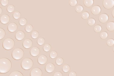 Sırayla şeffaf jel ya da su damlaları. Bej bir arkaplanda.