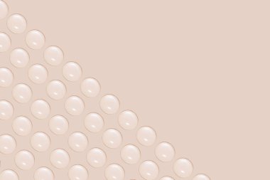 Sırayla şeffaf jel ya da su damlaları. Bej bir arkaplanda.