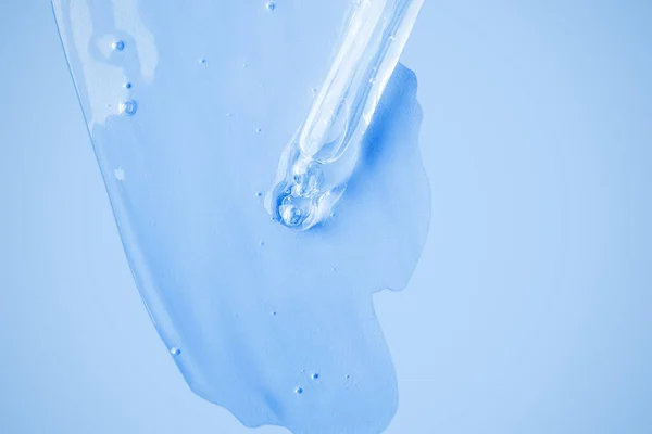 Átlátszó Kozmetikai Gél Folyik Csepegtető Elkenődött Háttérben Kék Háttérrel Hialuronsav — Stock Fotó
