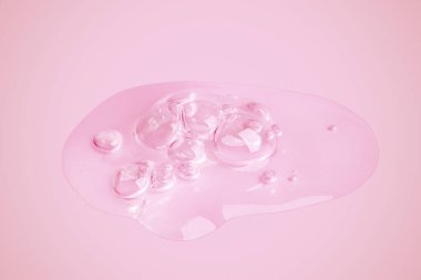 Pembe arka plana bulaşmış saydam bir jel damlası..