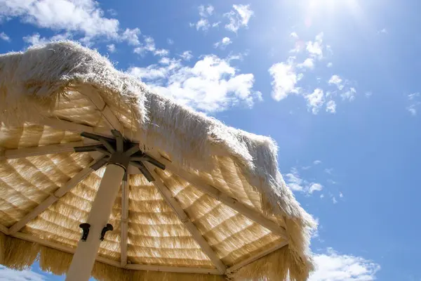 白いわらの傘は空に対してビーチで — ストック写真