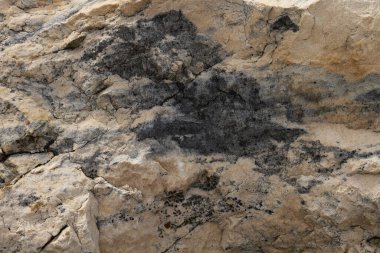 Taşın dokusu çentikli ve benekli. Delikler taştaki oyukları deliyor..