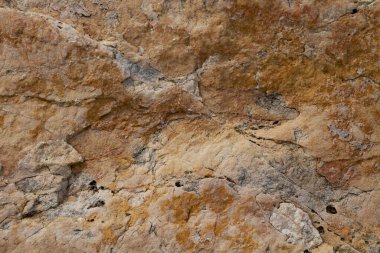 Taşın dokusu çentikli ve benekli. Delikler taştaki oyukları deliyor..