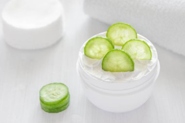 Beyaz bir kavanozda saf beyaz salatalık nemlendirici. Beyaz havlu. Yeşil Salatalık.