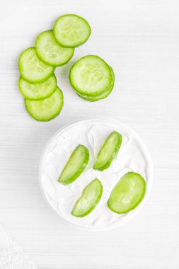 Beyaz bir kavanozda saf beyaz salatalık nemlendirici. Beyaz havlu. Yeşil Salatalık.