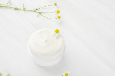 Beyaz bir kavanozda papatya çayı ile besleyici krema..