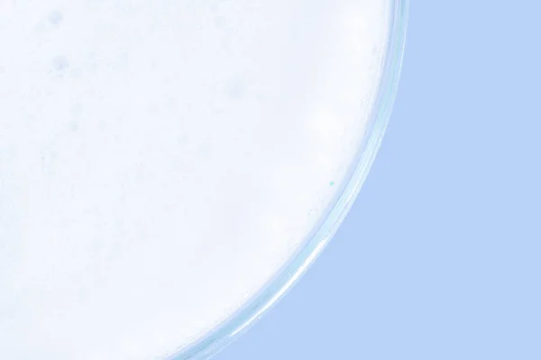洗涤剂泡沫在培养皿中 蓝色背景的 — 图库照片