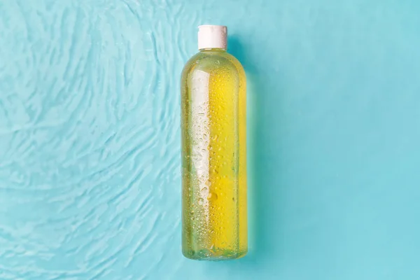 Żółty Tonik Butelce Tle Niebieskiej Wody — Zdjęcie stockowe