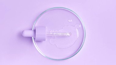 Mor arka planda bir petri kabında jel, serum ve serumla kozmetik pipeti.