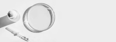 Petri kabı. Sarı sıvıyla. Çözümle. Kozmetik pipeti. Komedi şişesi. Beyaz bir arkaplanda.