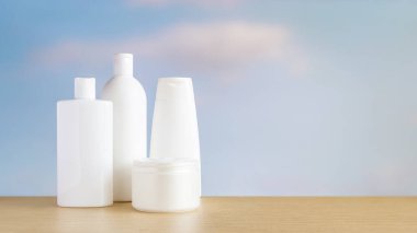 Gökyüzü arka planına karşı kozmetik şişeler ve kremler.