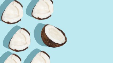 Hindistan cevizi arka planı. Mavi arka planda dağınık hindistan cevizi ve parçalar..