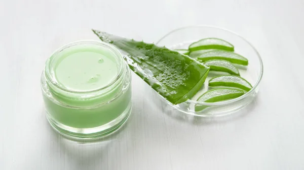 绿色芦荟维拉凝胶 在一个浅背景的罐子里豌豆菜 芦荟片 — 图库照片