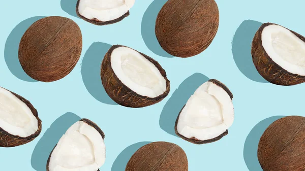Kontekst Kokosowy Rozrzucone Kokosy Kawałki Orzechów Kokosowych Niebieskim Tle — Zdjęcie stockowe