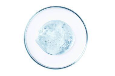 Boş bir arkaplanda şeffaf jel ya da serum olan bir petri kabı..