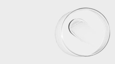 Hafif arka planda bir petri kabı, şeffaf jel lekeleri. Boş yer