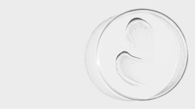 Hafif arka planda bir petri kabı, şeffaf jel lekeleri. Boş yer