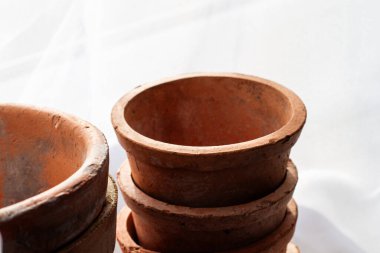 Tedavi edilmemiş kil kaplar. Turuncu renk. Sonbahar havası. Narin beyaz bir perdenin arkasında. Gün ışığı. Doğal renk.