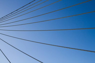 Mavi gökyüzüne karşı sırayla gerilmiş ipler.