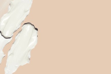 Bej arka planda kozmetik krem lekeleri.