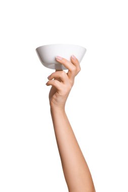 Boş arka planda boş beyaz tabak tutan bir kadının eli