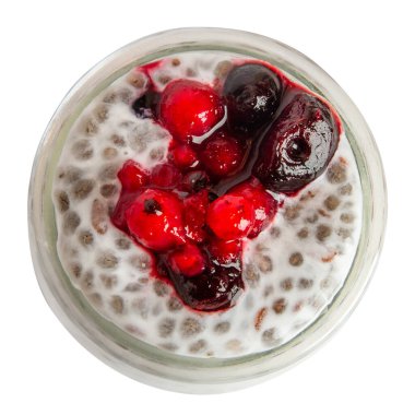 Bir kavanoz yoğurt, içinde chia tohumu ve böğürtlen var. Boş bir arkaplanda