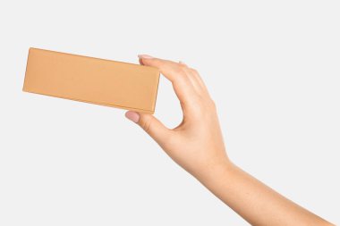 Bir kadının eli arka planda karton bir kutu tutuyor.