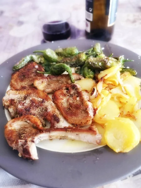 dish with lamb chops, bakery potatoes, peppers,