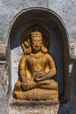 Katmandu sokaklarında düşünmek ve dua etmek için oturan Buda heykeli.